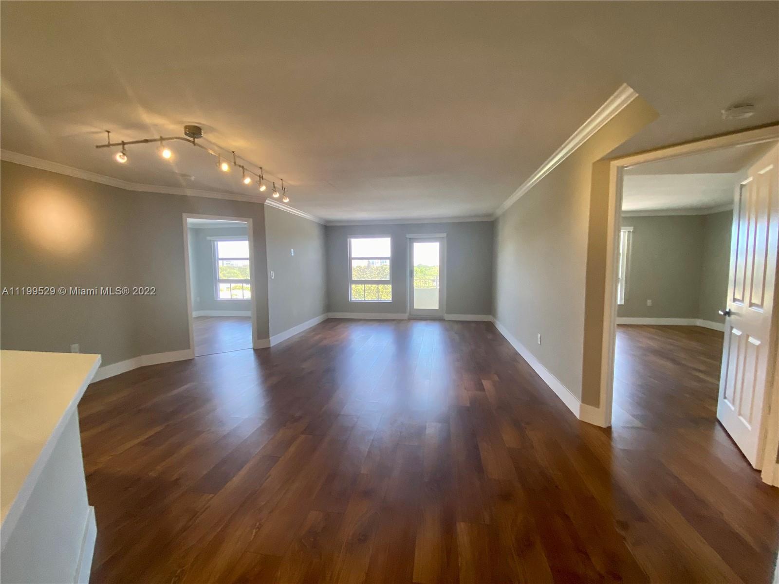 a view of wooden floor and windows in an empty room
