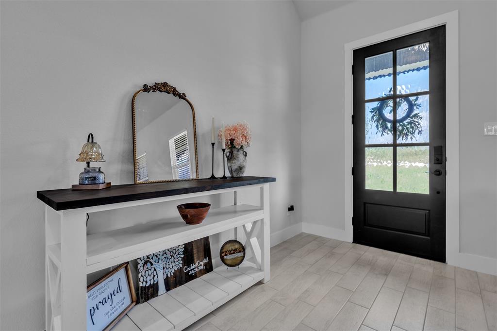 2004 Willy Dilly Road Springtown, TX 76082 - Photo 8 of 40 Black multi-pane entry door with light-colored plank flooring and white baseboards