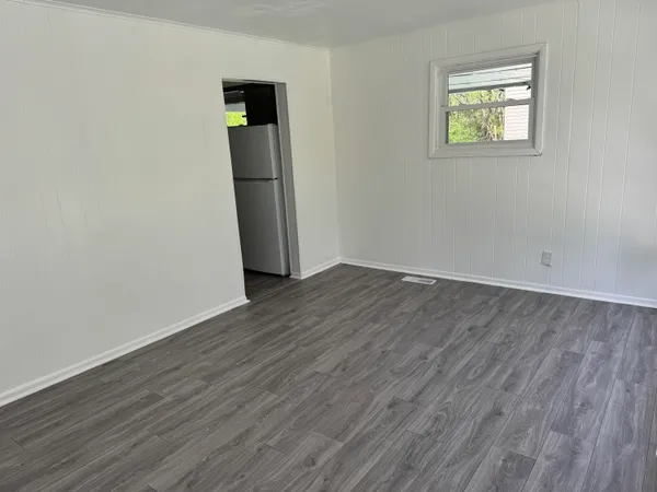an empty room with wooden floor and closet