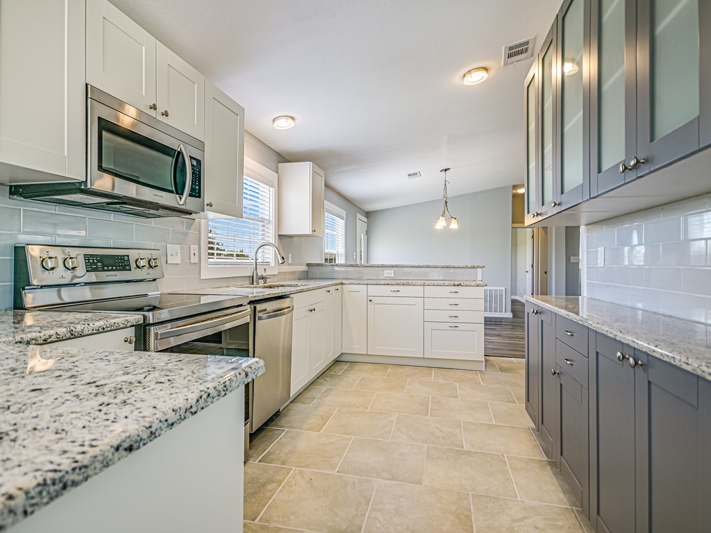 a kitchen with stainless steel appliances granite countertop a stove top oven a sink and dishwasher