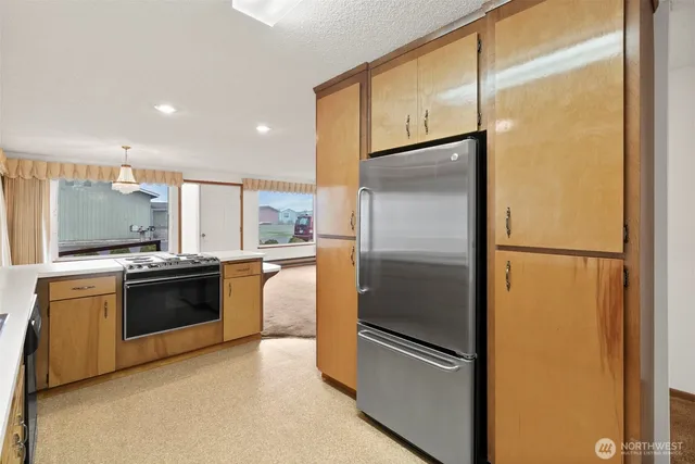 a kitchen with stainless steel appliances and refrigerator