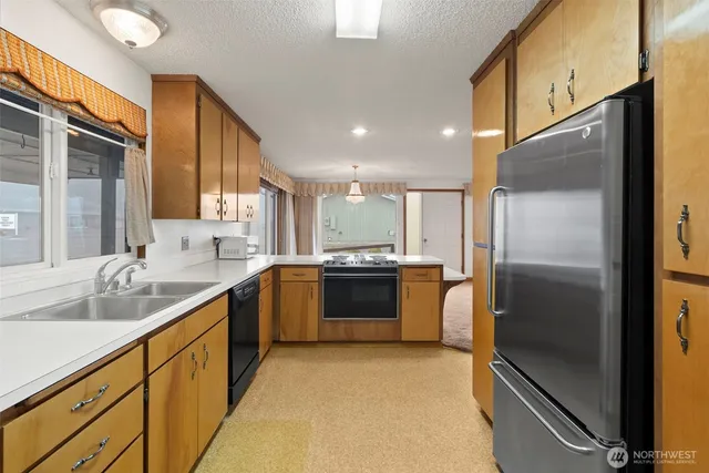 a large kitchen with a large window and stainless steel appliances