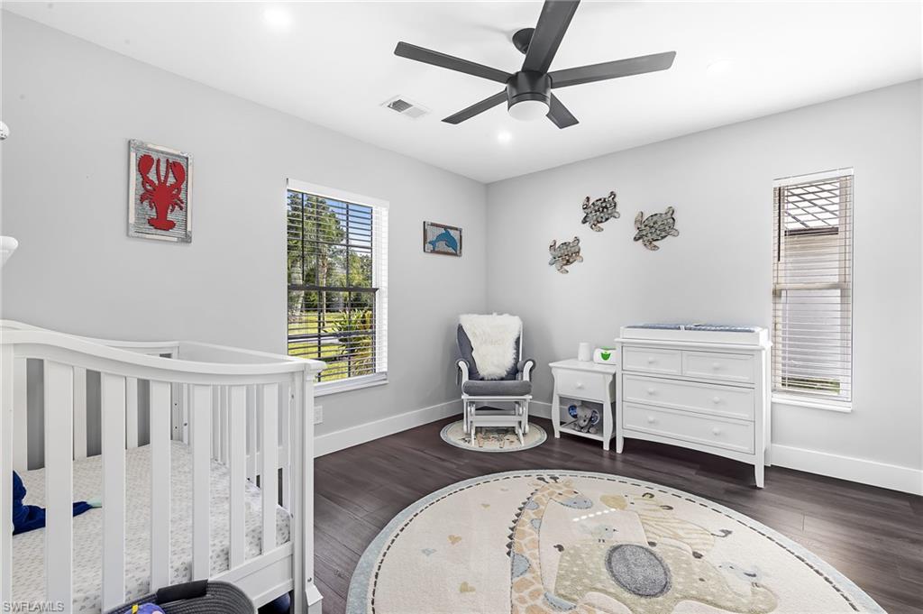 1330 Rock Road Naples, FL 34120 - Photo 14 of 37 Bedroom with baseboards, visible vents, a crib, and wood finished floors
