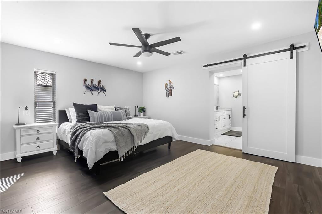 1330 Rock Road Naples, FL 34120 - Photo 15 of 37 Bedroom with recessed lighting, visible vents, a barn door, and dark wood-type flooring