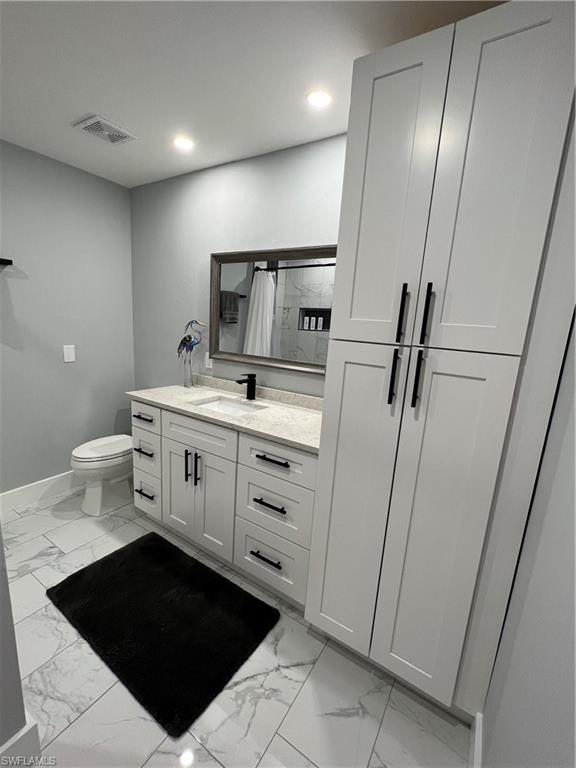 1330 Rock Road Naples, FL 34120 - Photo 19 of 37 Full bath with baseboards, visible vents, marble finish floor, and vanity