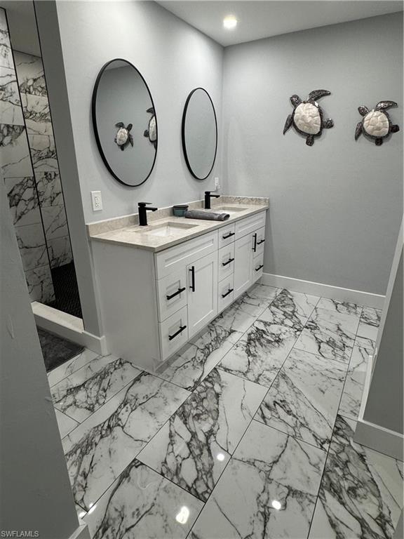 1330 Rock Road Naples, FL 34120 - Photo 22 of 37 Full bath featuring a tile shower, a sink, double vanity, marble finish floor, and baseboards