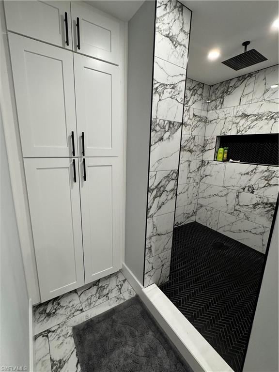 1330 Rock Road Naples, FL 34120 - Photo 24 of 37 Full bathroom with baseboards, marble finish floor, and tiled shower