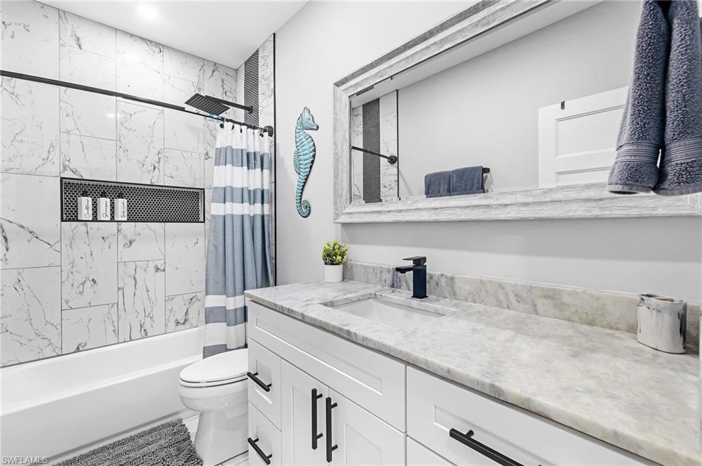 1330 Rock Road Naples, FL 34120 - Photo 31 of 37 Full bathroom featuring vanity, shower / bathtub combination with curtain, and toilet