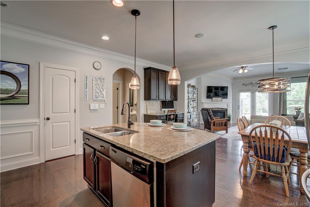 1633 Ridgehaven Road Waxhaw, NC 28173 - Photo 9 of 48 a kitchen with stainless steel appliances granite countertop stove top oven a refrigerator and dining table with wooden floor
