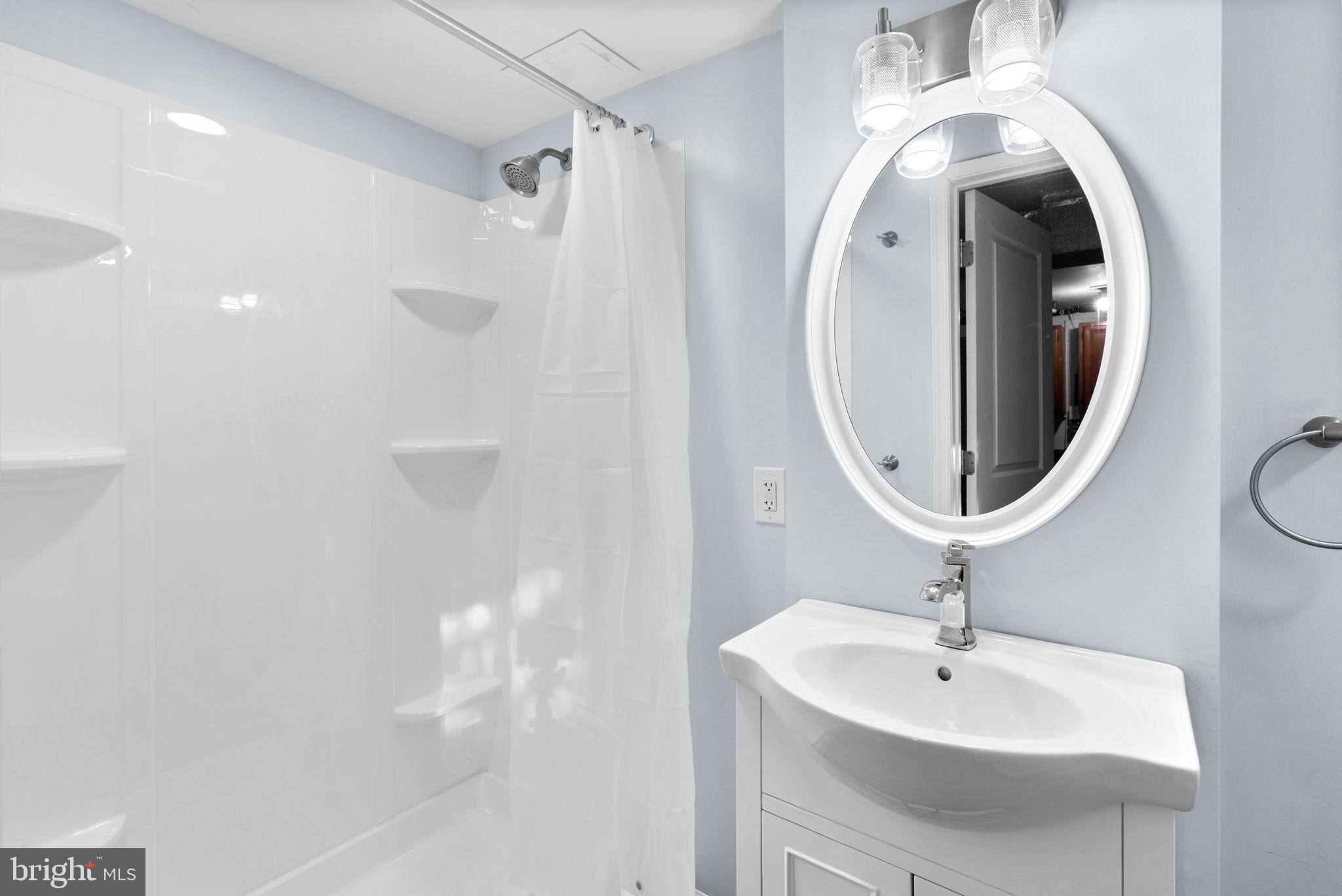 324 Stanmore Road Baltimore, MD 21212 - Photo 25 of 40 a bathroom with a sink a mirror and a shower