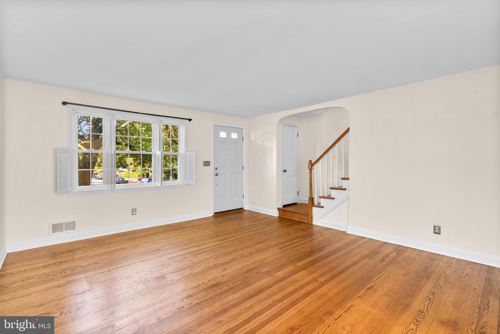 324 Stanmore Road Baltimore, MD 21212 - Photo 6 of 40 a view of an empty room with wooden floor and a window