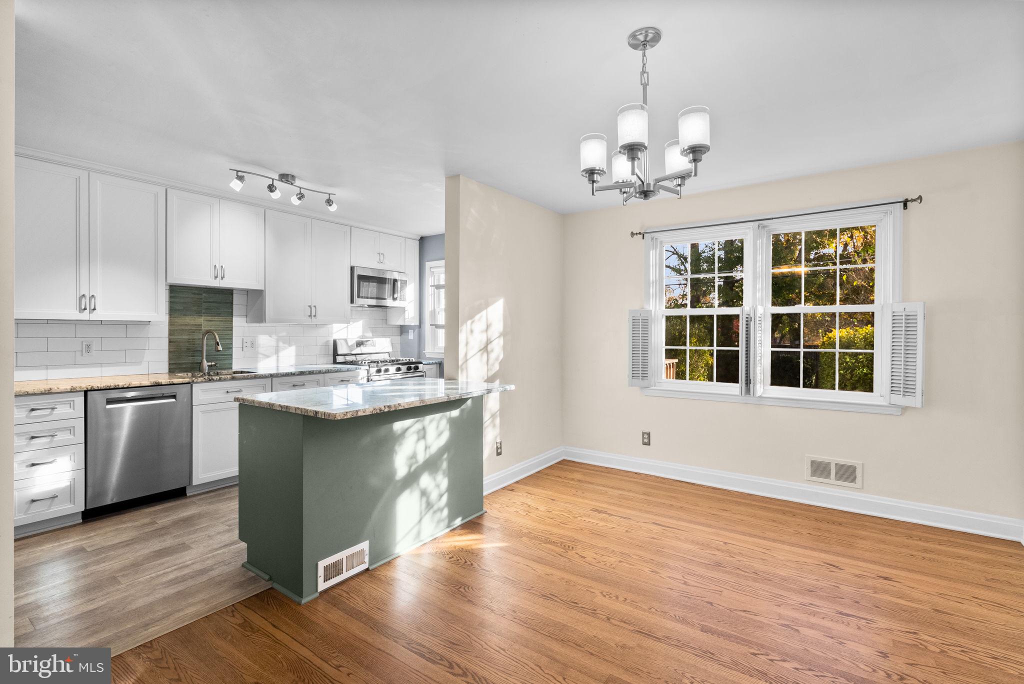 324 Stanmore Road Baltimore, MD 21212 - Photo 9 of 40 a kitchen with stainless steel appliances granite countertop a sink dishwasher a refrigerator and a stove with wooden floor