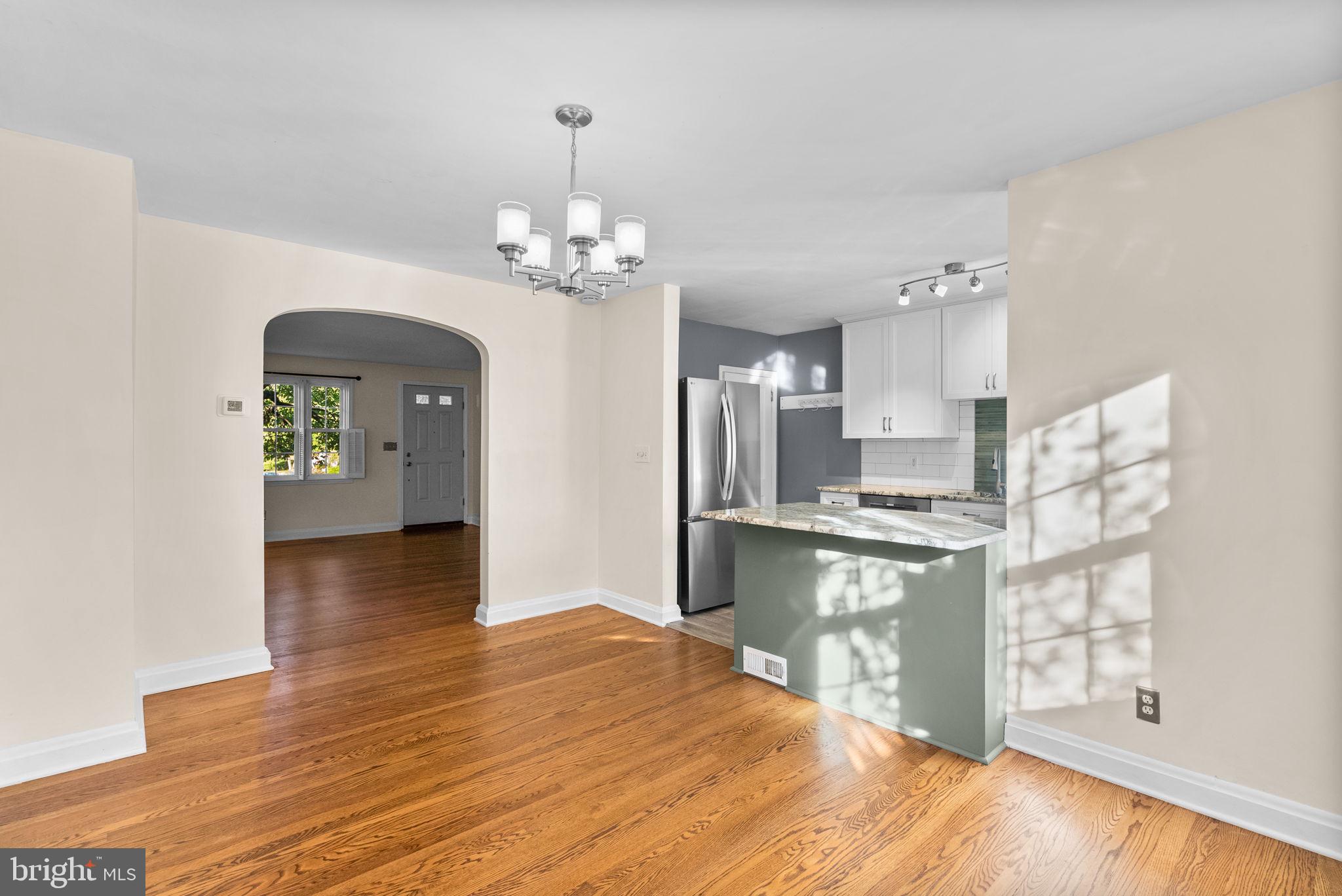 324 Stanmore Road Baltimore, MD 21212 - Photo 10 of 40 a open kitchen with stainless steel appliances granite countertop a refrigerator a stove oven a sink dishwasher and white cabinets with wooden floor