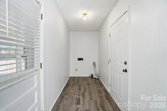 a view of a hallway with wooden floor and entryway