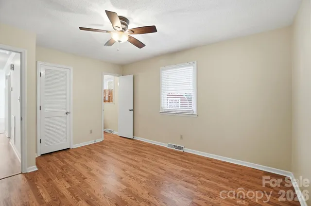 a view of a big room with wooden floor and a ceiling fan
