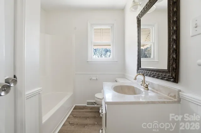a bathroom with a tub sink and mirror