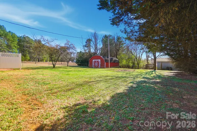 a view of yard with swimming pool and trees