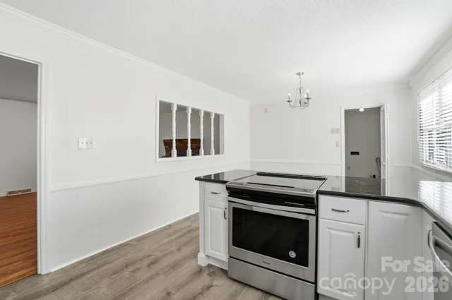 a kitchen with granite countertop white cabinets and white appliances