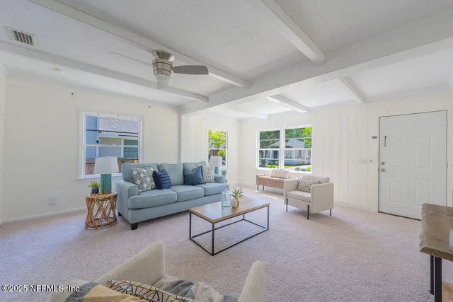 an empty room with windows and couches