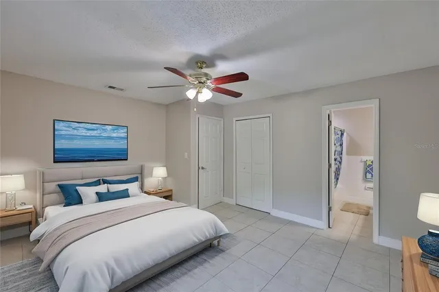 a bedroom with a large bed and a chandelier