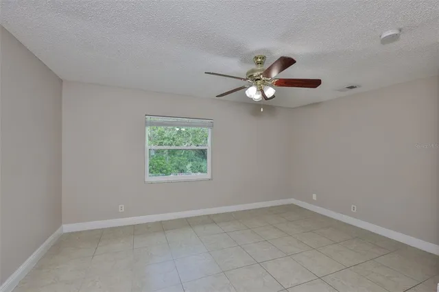 an empty room with closet and a ceiling fan