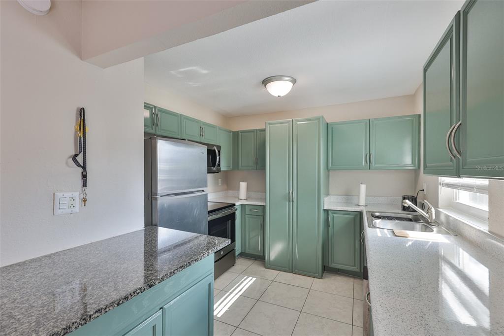 13125 Wilcox Road, Unit 16202 Largo, FL 33774 - Photo 2 of 37 a kitchen with granite countertop a refrigerator and a sink