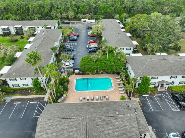 an aerial view of residential houses with outdoor space and trees