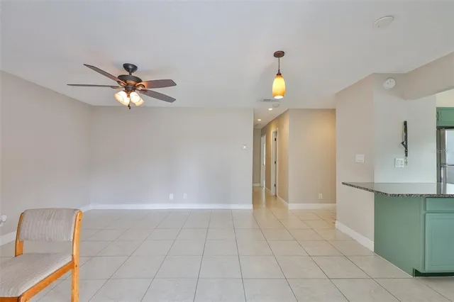 a view of an empty room and chandelier fan