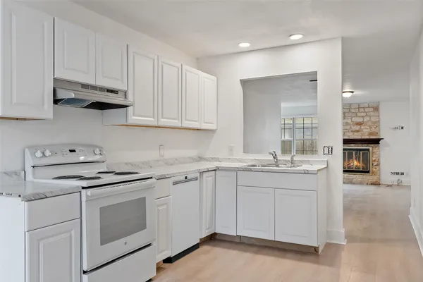 a kitchen with white cabinets and white appliances