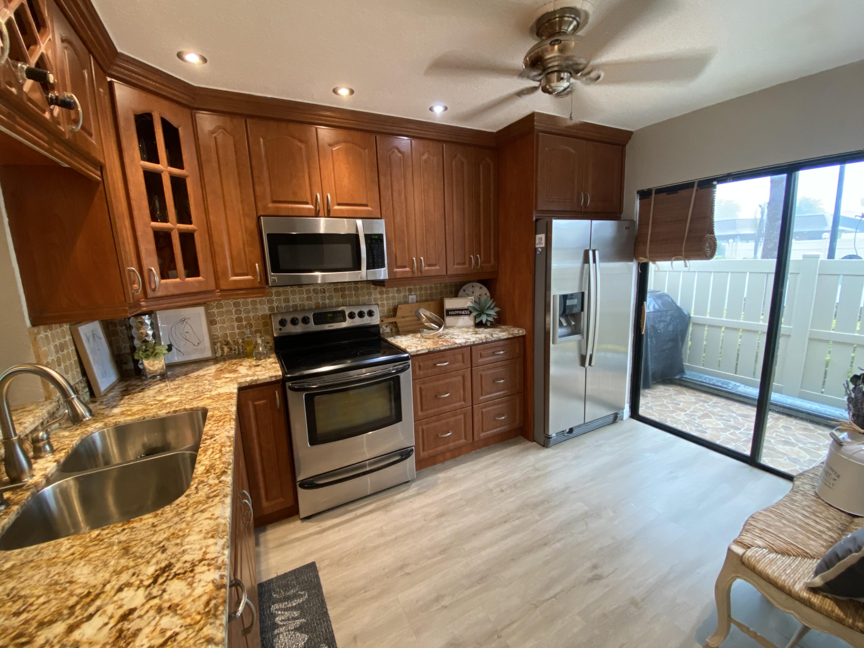 595 Banks Road Margate, FL 33063 - Photo 18 of 35 a kitchen with stainless steel appliances granite countertop a refrigerator a stove top oven a sink and dishwasher