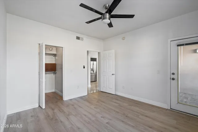 an empty room with wooden floor and windows