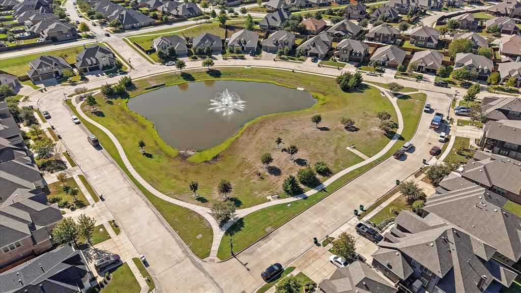 2044 Longbridge Road Forney, TX 75126 - Photo 38 of 40 Centrally located pond with a water feature, surrounded by paved walkways, and mature trees