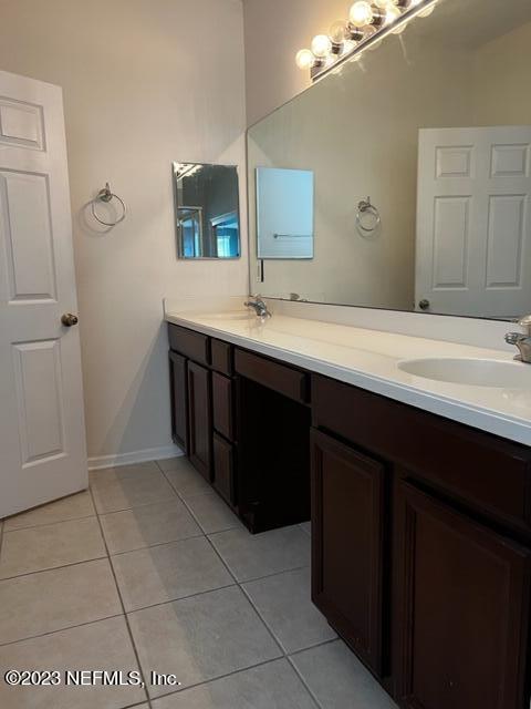3121 East Banister Road St. Augustine, FL 32092 - Photo 16 of 31 a bathroom with a double vanity sink and mirror