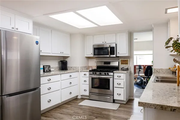 a kitchen with stainless steel appliances granite countertop a refrigerator stove and sink