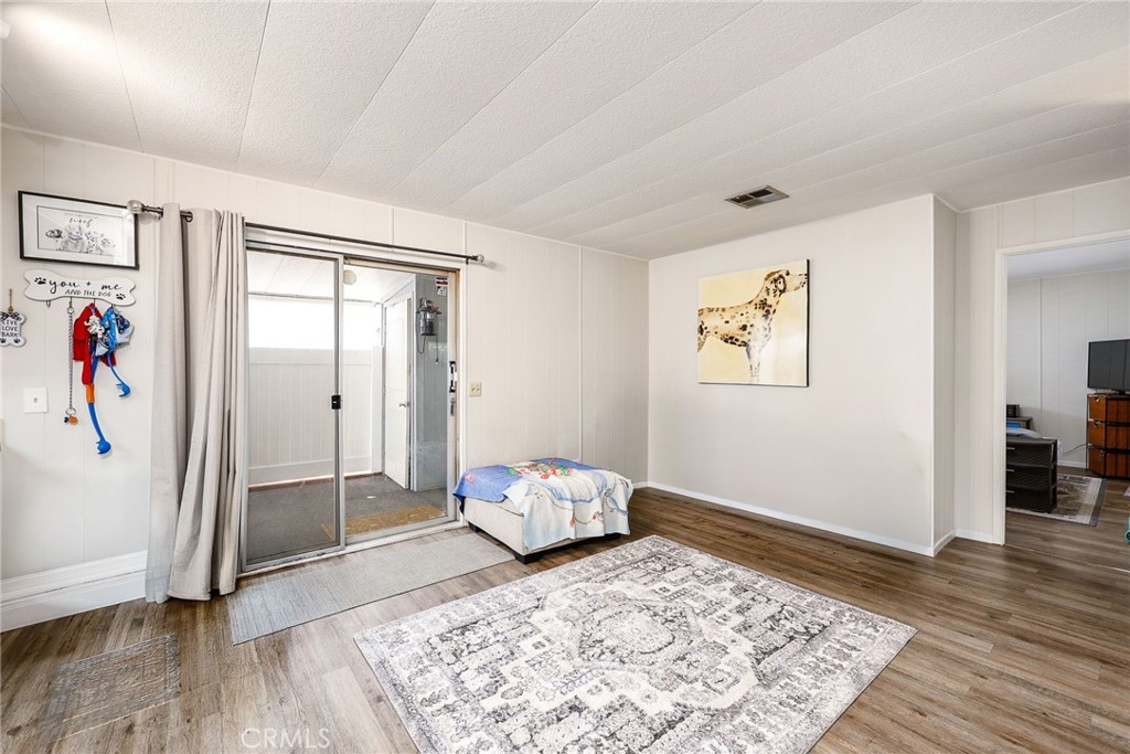 1120 East Mission Road, Unit 79 Fallbrook, CA 92028 - Photo 13 of 43 a bedroom with a bed and wooden floor