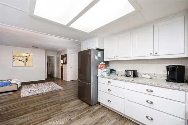 a kitchen with granite countertop cabinets and refrigerator