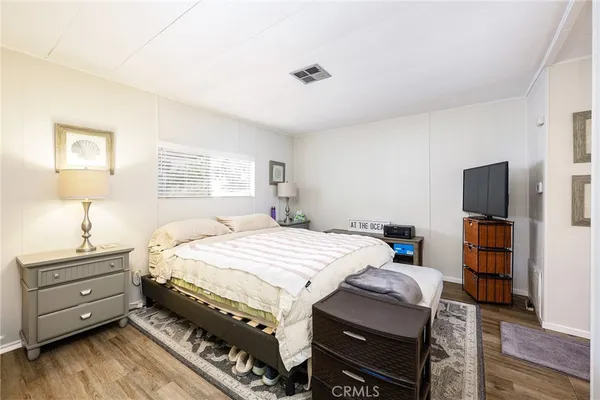 a bedroom with a bed and a tv on the dresser