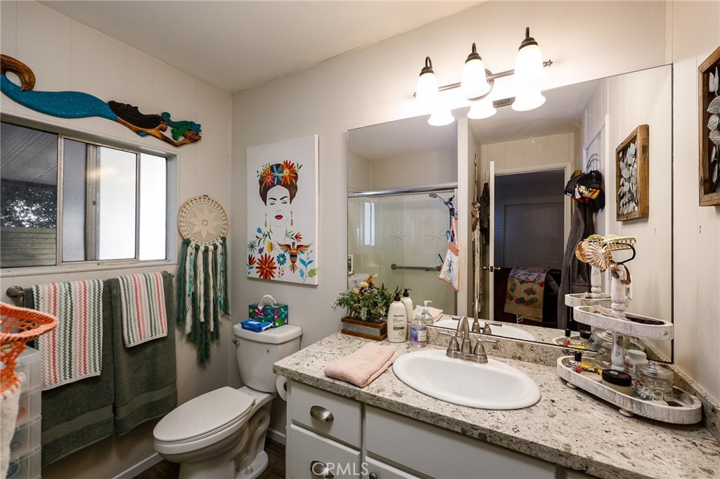 1120 East Mission Road, Unit 79 Fallbrook, CA 92028 - Photo 22 of 45 a bathroom with a granite countertop sink mirror vanity and toilet