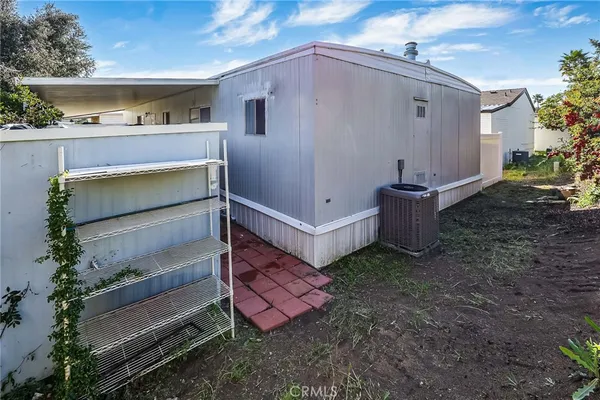 a view of a small house with yard and sitting area