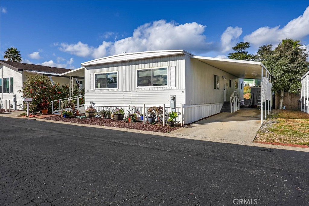1120 East Mission Road, Unit 79 Fallbrook, CA 92028 - Photo 29 of 43 a front view of a house with a yard and garage