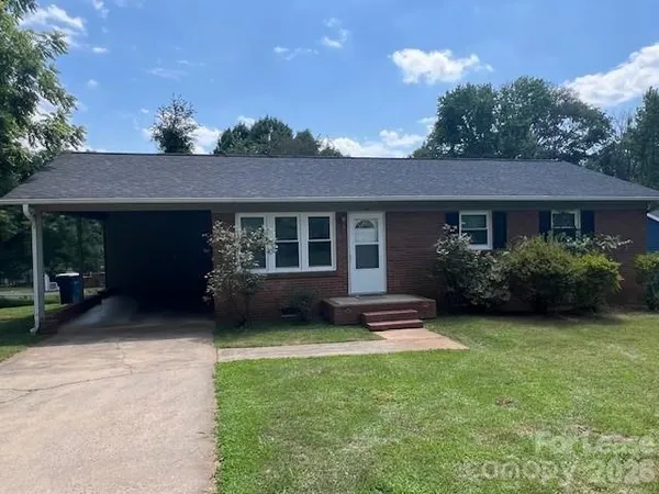 a front view of a house with a garden and plants