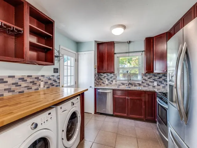 a view of a kitchen with stainless steel appliances granite countertop a sink and a stove