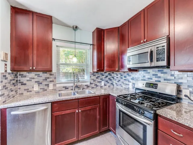 a kitchen with sink cabinets and stainless steel appliances