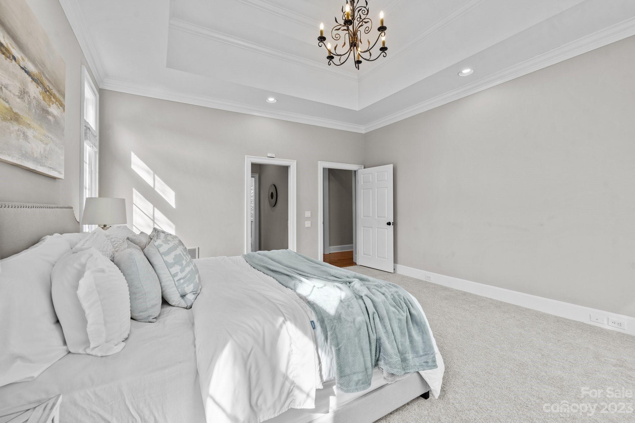 4732 Old Course Drive Charlotte, NC 28277 - Photo 14 of 48 a bedroom with a bed and a chandelier