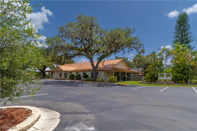 a view of a white house with a yard and sitting area
