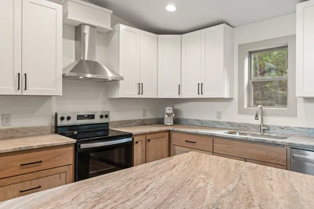 a kitchen with stainless steel appliances granite countertop white cabinets and a sink