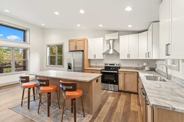 a kitchen with stainless steel appliances granite countertop white cabinets a sink and a stove