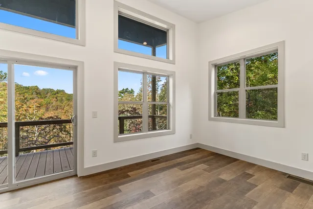 an empty room with wooden floor and windows