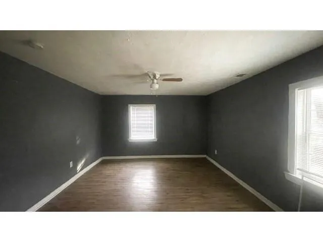 a kitchen with a window and wooden floor