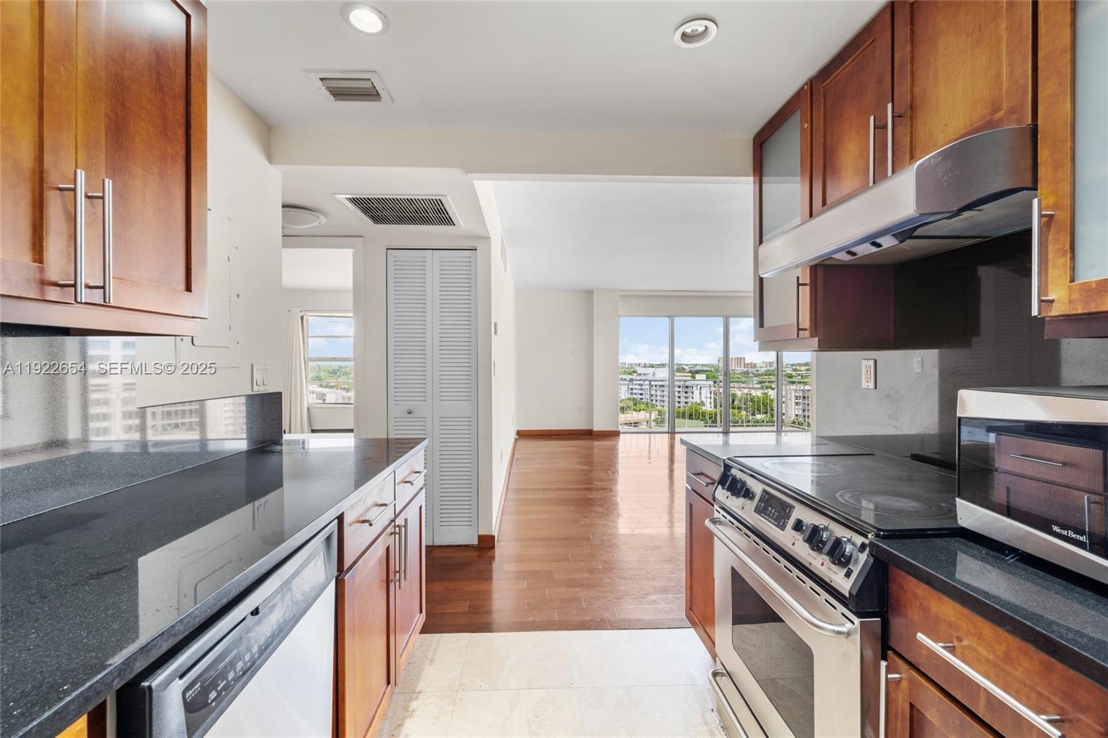 11111 Biscayne Boulevard, Unit 10H Miami, FL 33181 - Photo 2 of 22 a kitchen with stainless steel appliances granite countertop a stove a sink and a microwave